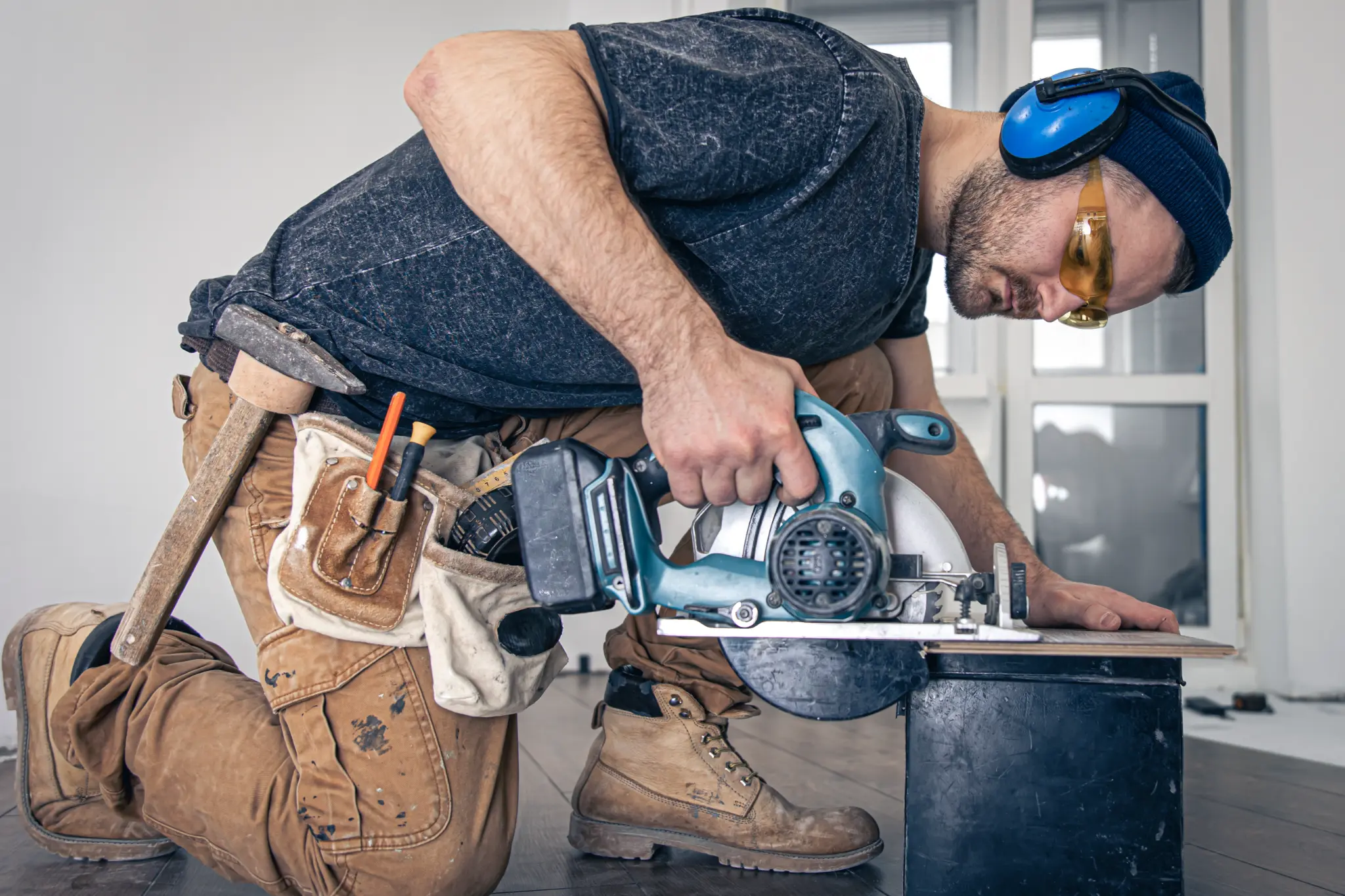 Carpenter carefully cutting wood with a circular saw